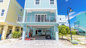 A two-story building with a balcony, a covered entrance, and a paved driveway.