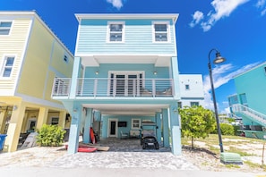 A two-story building with a balcony, a covered entrance, and a paved driveway.