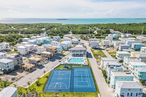 A residential area with modern houses, a swimming pool, and a basketball court.