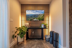 A hallway with a television mounted on a wall displaying a scenic landscape. - Secluded Luxury Glacier NP (Whitefish)
