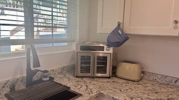 A kitchen with a built-in oven, a toaster, and a sink.