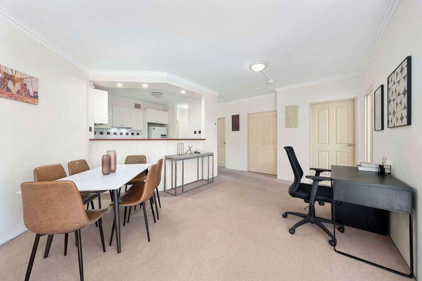 A modern interior with a dining area, kitchen, and office space.