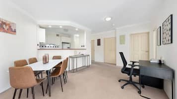 A modern interior with a dining area, kitchen, and office space.