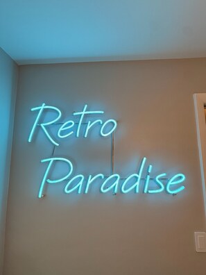 A neon sign with the words 'Retro Paradise' on a wall. - Retro styled paradise 3bed/2br Cape Coral pool home on the canal front (Cape Coral)