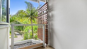 Ein Balkon mit Blick auf Palmen und eine Straße.