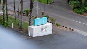 A sign for 'DRIFT APARTMENTS' with a teal signboard on a concrete base. - Palm Cove Apartment with Resort Pool, Gym and Parking | 2308 Drift (Palm Cove)