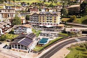 Ein Hotel mit mehreren Etagen, einem Schwimmbad und Solaranlagen.