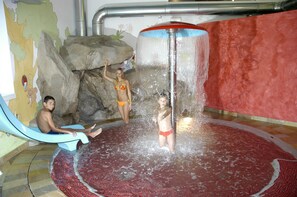 Ein Wasserspielbereich mit Rutschen und einer zentralen Wassersäule.