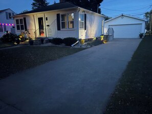 A single-story house with a front porch, a garage, and a well-maintained lawn. - Cozy 2-bedroom house in pleasant Green Bay with AC (Green Bay)