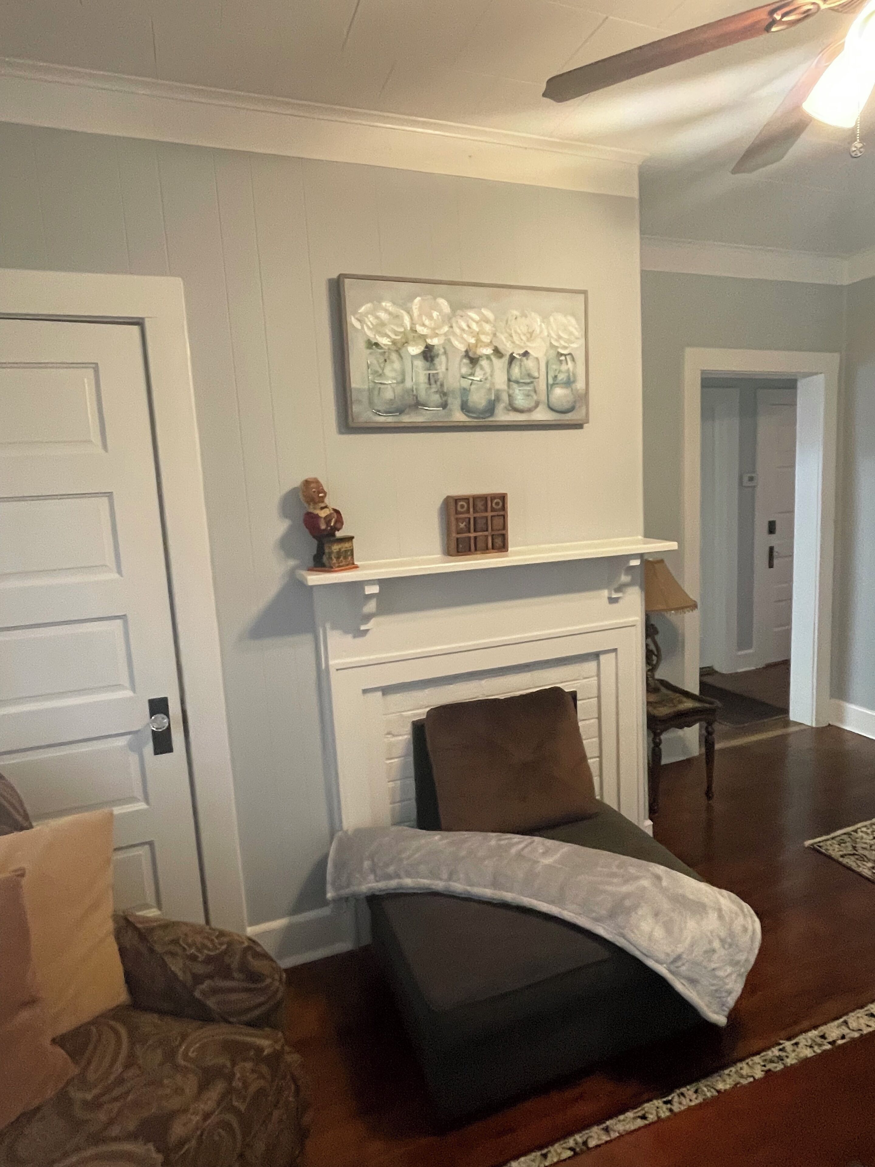 A living room with a fireplace, a sofa, a coffee table, and a door.