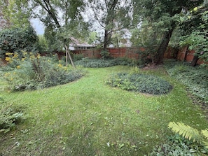A garden with various plants and a wooden fence. - Cozy home minutes from SU campus, area hospitals & all major highways. (Syracuse)