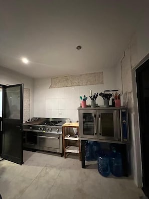 Una cocina con estufa a gas, horno, microondas y armarios.
