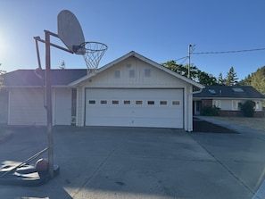 A residential garage with a basketball hoop and a driveway.