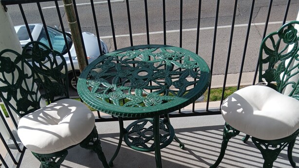 A green metal table with a white cushioned bench on a balcony. - Cozy 1-bedroom apartment in Beautiful Salt Lake City with W&D (Salt Lake City)