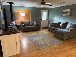 A living room with two sofas, a coffee table, a fireplace, and a ceiling fan. - A Charming 3-bedroom house on Toledo Bend lake with garage and boat house (Many)