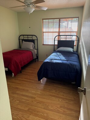 A bedroom with two single beds, a ceiling fan, and a window with blinds. -  A Charming  3-bedroom house on Toledo Bend lake with garage and boat house (Many)