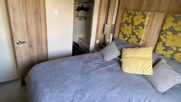 Ein Schlafzimmer mit einem Bett, einem Kleiderschrank und einem Spiegel.
