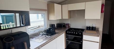 A compact kitchen with a stove, oven, and microwave.