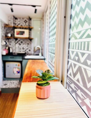 A modern kitchen with a wooden countertop and a potted plant. - The Hanoian Local Nest - Old Quarter Heart - 5' to Hoankiem Lake & Beer street (Hà Nội)