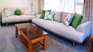 Un salón con dos sofás, una mesa de centro y una lámpara de pie.