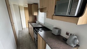 Eine kleine Küche mit Mikrowelle, Toaster und Wasserkocher auf der Arbeitsplatte.