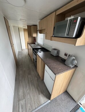 Eine kleine Küche mit Mikrowelle, Toaster und Wasserkocher auf der Arbeitsplatte.