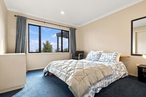 Une chambre à coucher avec un lit, une chaise, une fenêtre et un radiateur.