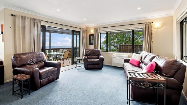 A spacious living area with leather sofas, a dining table, and a view of the outdoors. - Nelson On The Hill close to Nelson City (Nelson)
