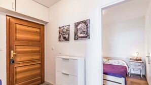 Un dormitori amb un llit, una nitòria, una làmpada i un armari.
