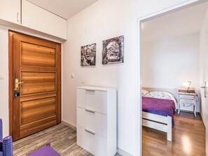 Een slaapkamer met een bed, nachtkastje, lamp en een kledingkast.