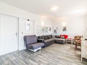 A modern living room with a grey sectional sofa, a small table, and a floral armchair.