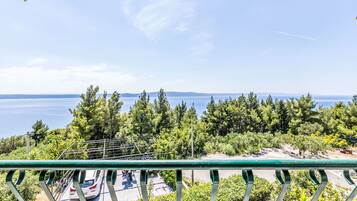 A balcony with a view of a parking area and a body of water.
