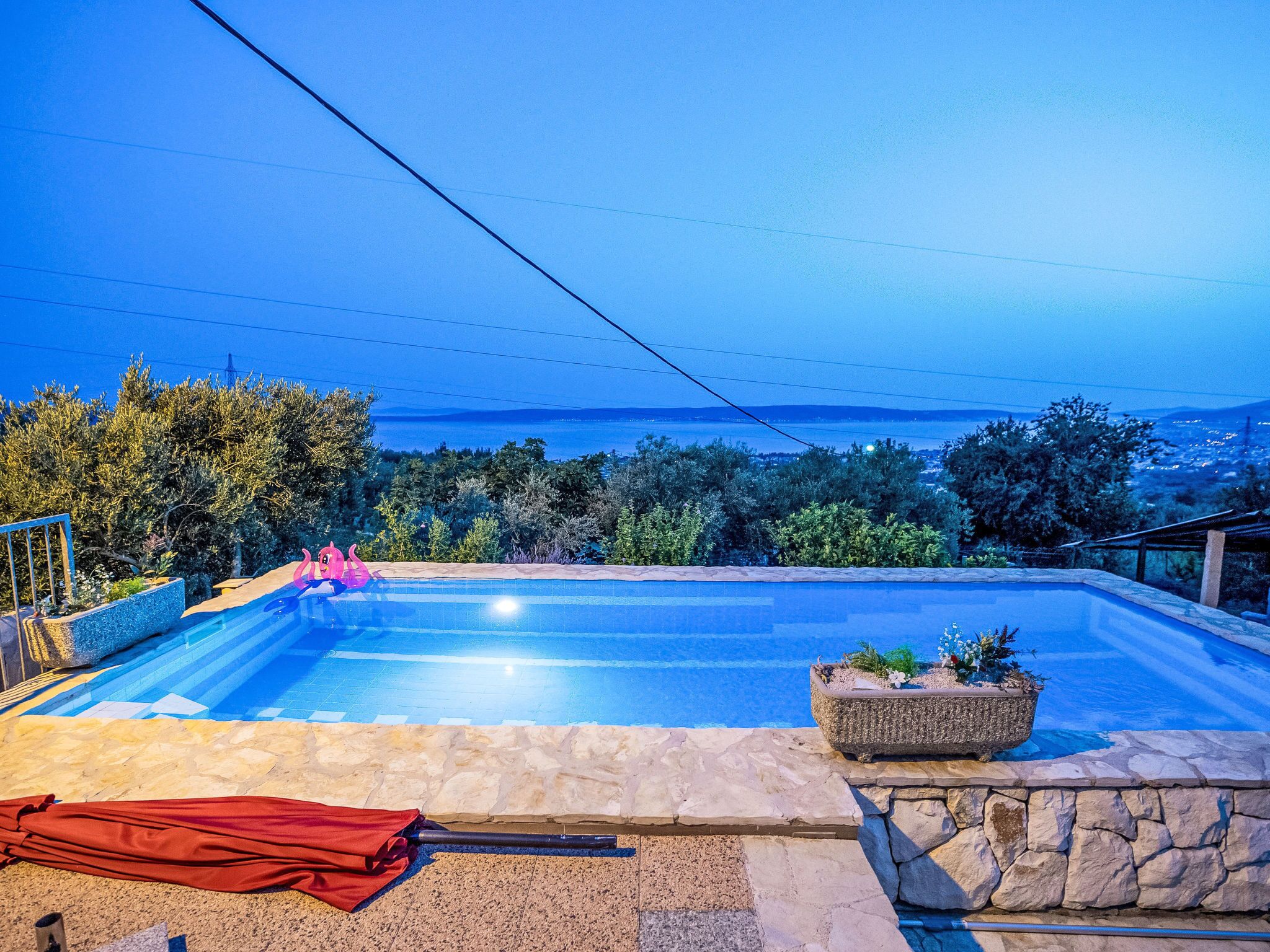 Ein Schwimmbecken mit Blick auf das Meer und Berge im Hintergrund.