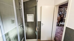 Un baño con ducha, inodoro y lavamanos.
