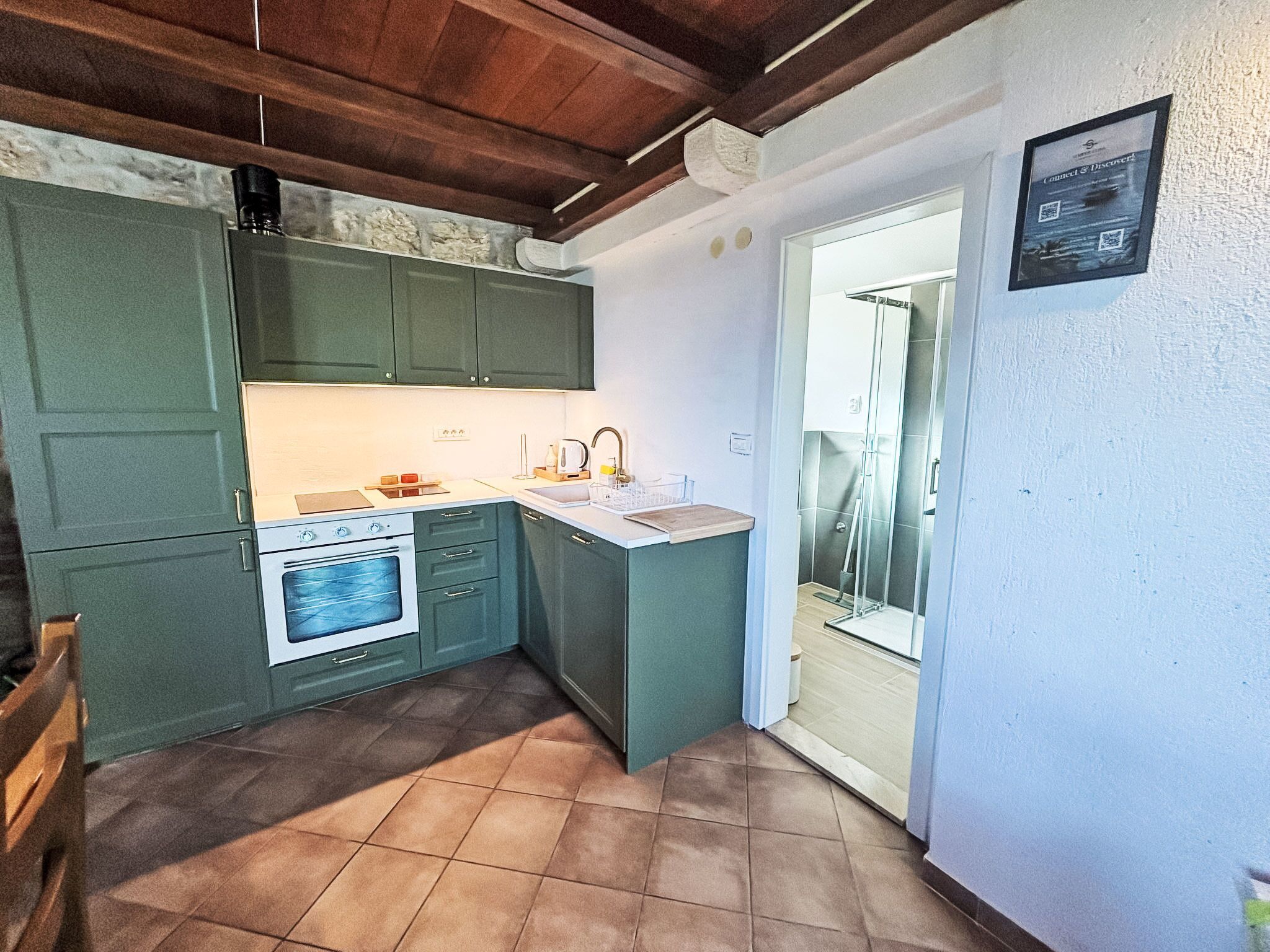 Una cocina compacta con horno integrado, un lavamanos y una pequeña encimera.