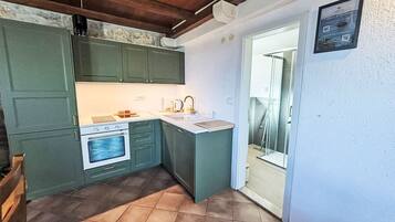 A compact kitchen with a built-in oven, a sink, and a small countertop.