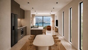A modern kitchen with a dining area, large windows, and a view of the outdoors. - Lakehouse 62 – Brand New Lakefront Villa with Spa (Queenstown)