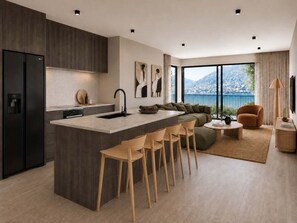 Et moderne køkken med en central ø, barstole og et spiseområde med sofa og sofabord.