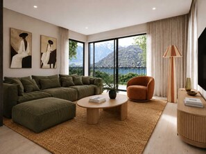 A modern living room with a sectional sofa, a round coffee table, a single armchair, and a view of a mountainous landscape through large windows. - Lakehouse 62 – Brand New Lakefront Villa with Spa (Queenstown)