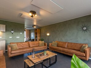 Un salon moderne avec deux canapés en cuir, une table basse en bois et un lampadaire.