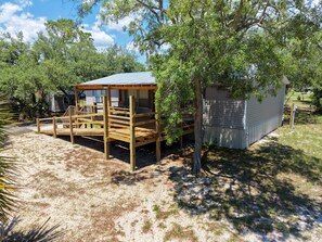 A wooden deck with a metal roof, a small shed, and a tree in a backyard. - Fisherman's Rest - Handicap Accessible! (Taylor County)
