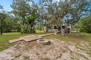 A wooden deck leading to a house with a porch, surrounded by trees and a grassy yard. - Fisherman's Rest - Handicap Accessible! (Taylor County)