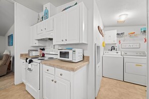 A modern kitchen with white cabinets, a microwave, stove, and a built-in oven. - Fisherman's Rest - Handicap Accessible! (Taylor County)