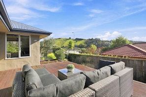 A patio with outdoor furniture, a small table, and a potted plant. - Location Plus Nelson family getaway (Nelson)