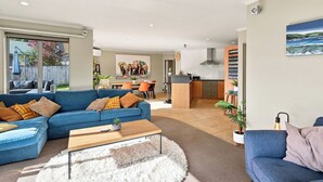 En moderne stue med en blå sofa, et sofabord og en blød måtte.