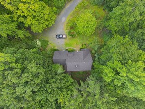 An aerial view of a house surrounded by dense green forest, with a road leading to it. - Private 7-Acre Retreat w/Brook, Near Hike & Ski (Townshend)
