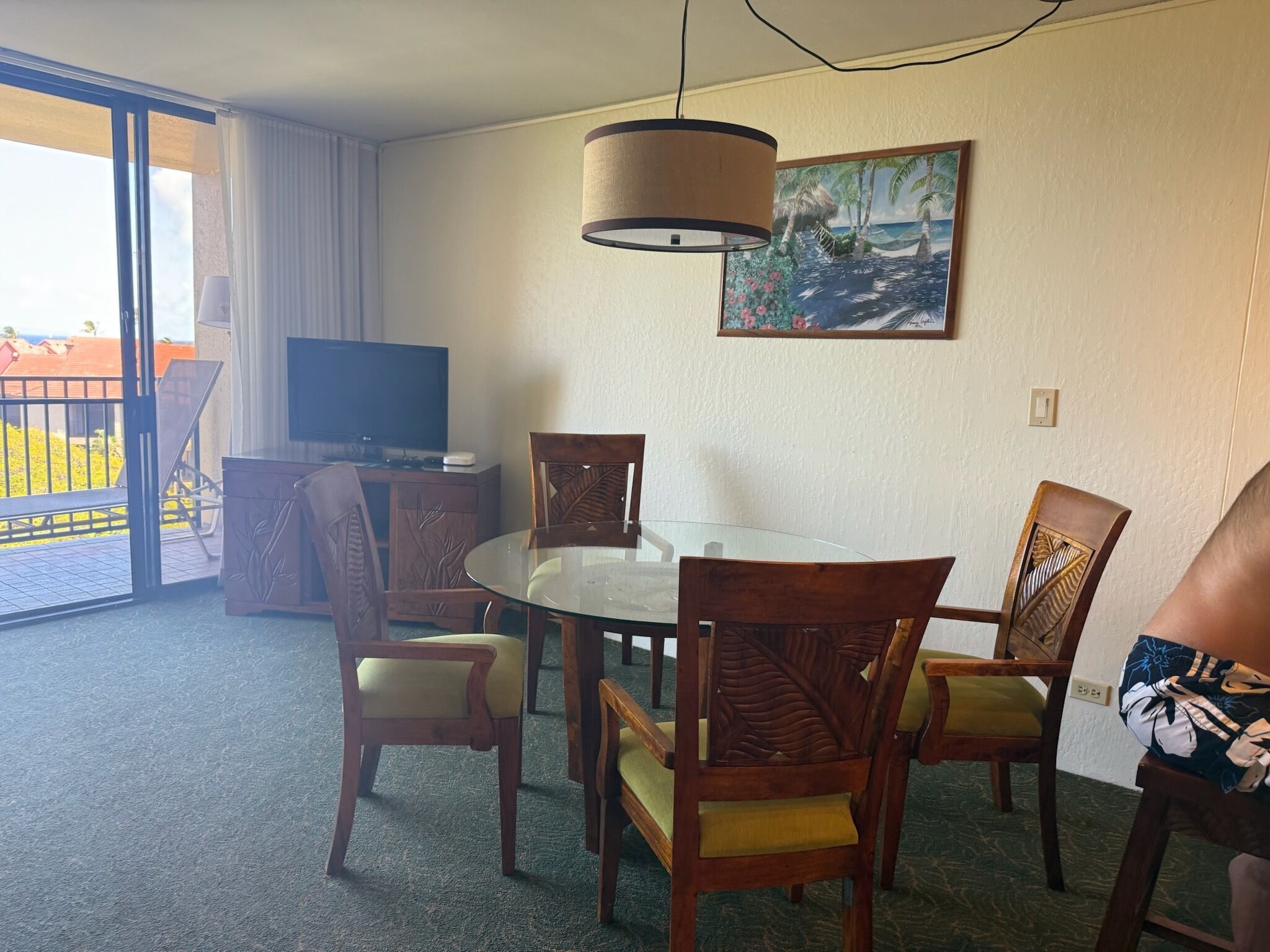 Une chambre d’hôtel équipée d’une table à manger, de chaises, d’un téléviseur et d’un tableau au mur.