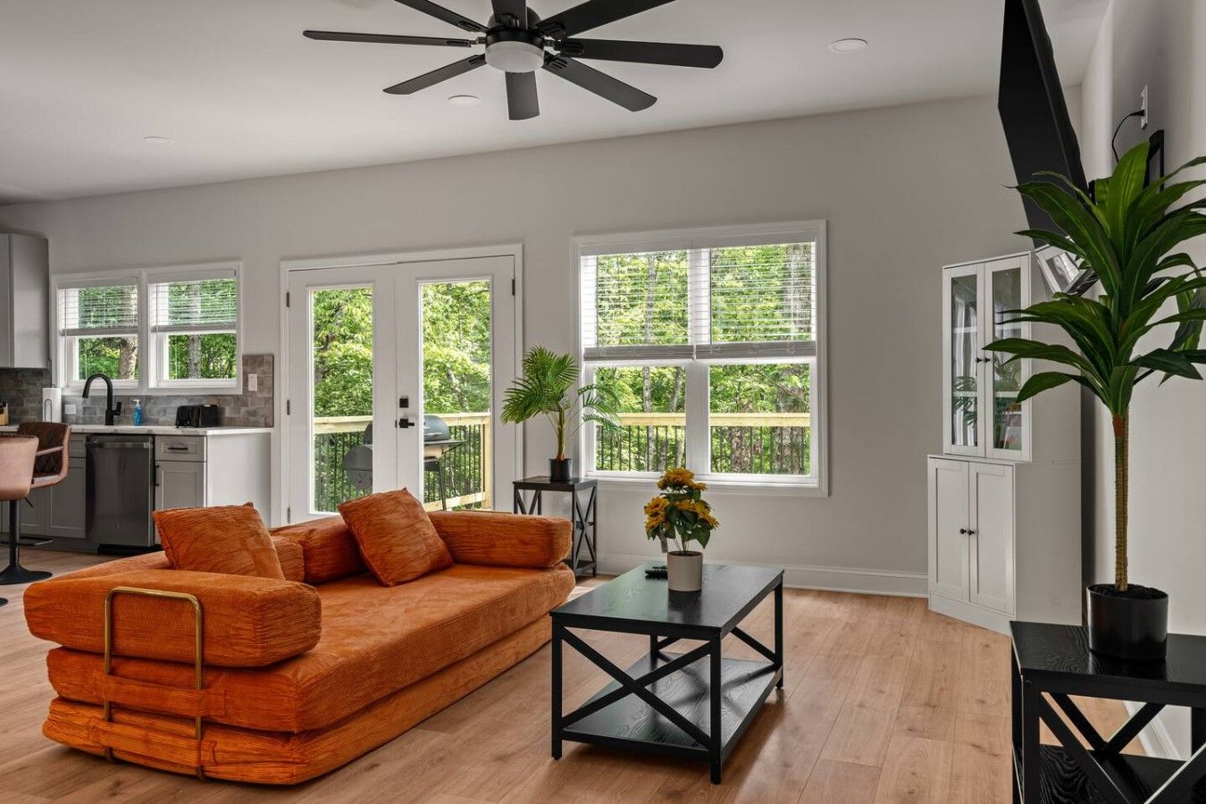 A modern living room with a sofa, a coffee table, and a ceiling fan.