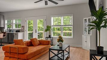 A modern living room with a sofa, a coffee table, and a ceiling fan.
