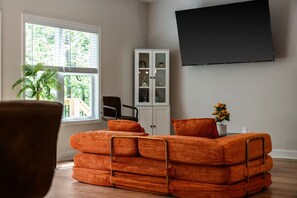 A living room with a sofa, a cabinet, a TV, and a window with blinds. - Bob`s Hilltop Paradise (Helen)